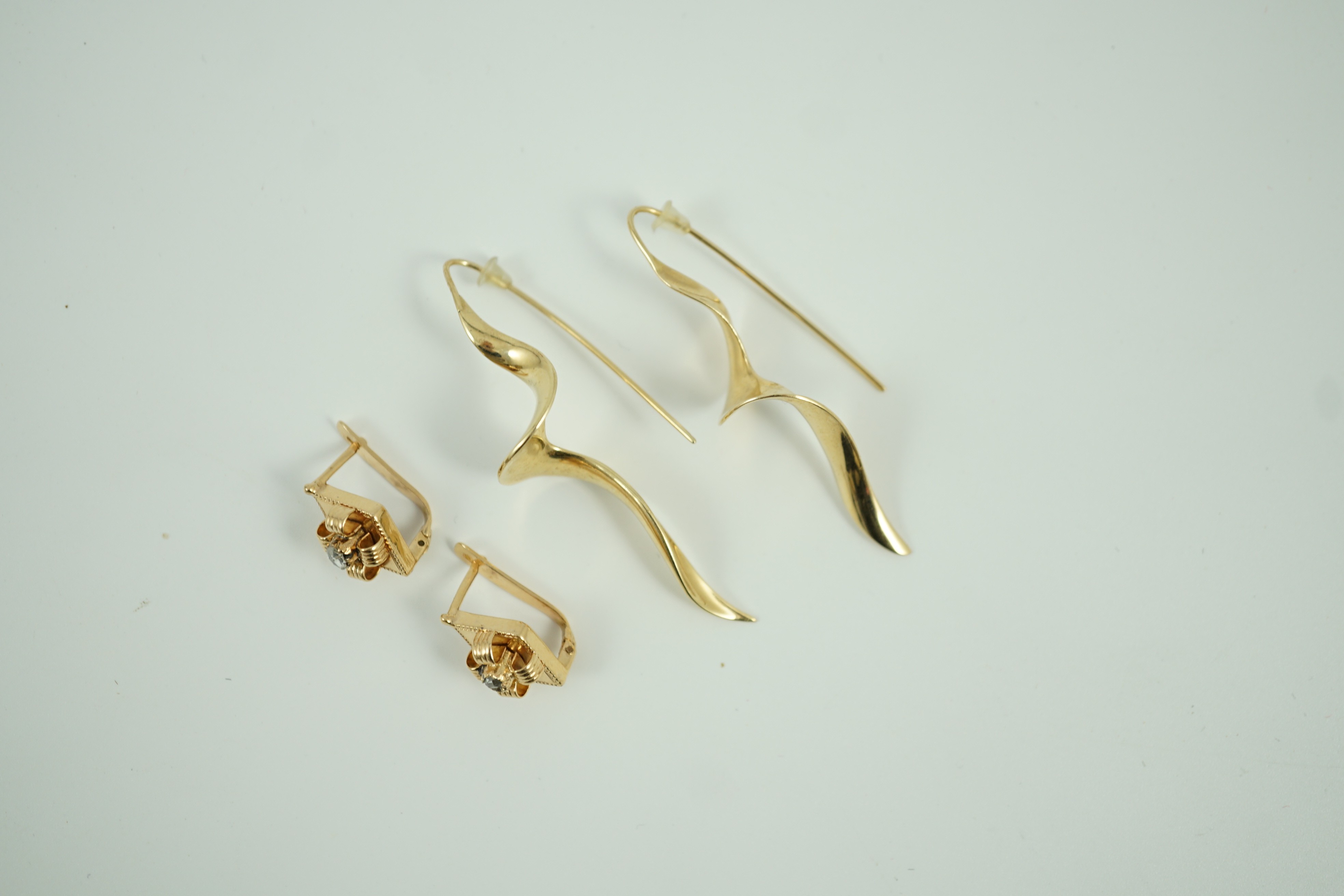 A modern pair of 14k spiral earrings, 50mm, 6.4 grams and a part of yellow metal and solitaire rose cut diamond set earrings, gross 4.2 grams.